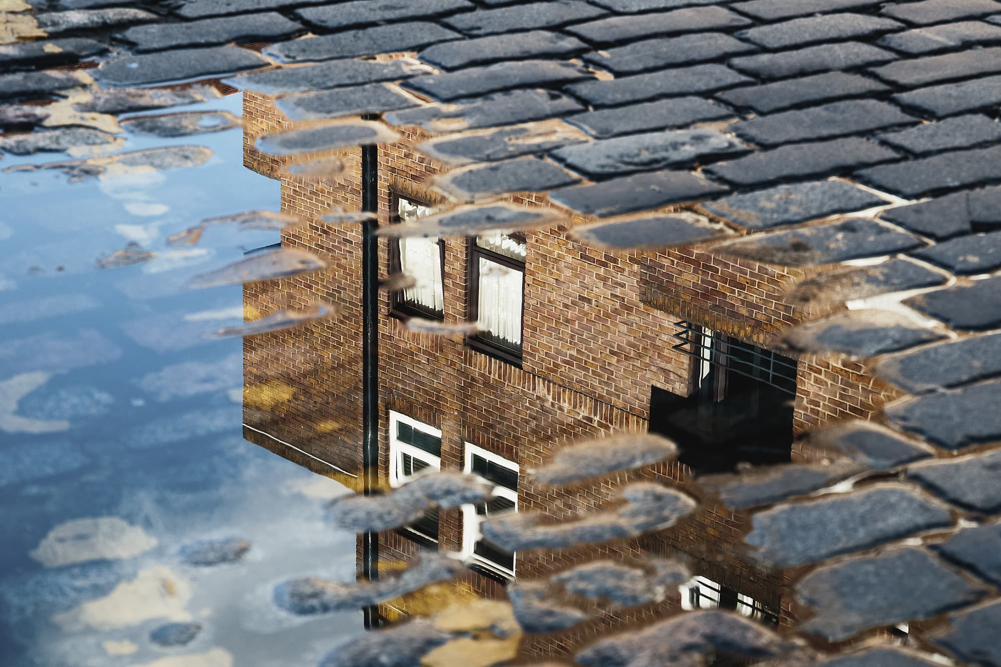 cobblestone-reflection-house-puddle-after-rain